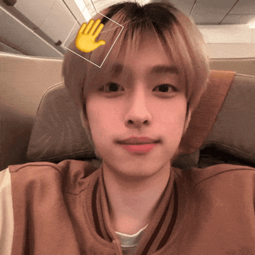 a young man with a hand on his forehead looks at the camera