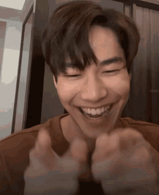 a close up of a person making a funny face with their hands