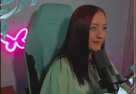 a young woman is sitting in a chair in front of a microphone .