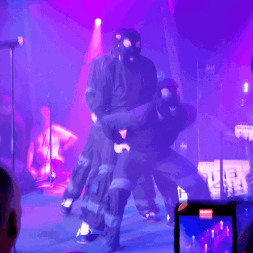 a man wearing a mask stands on a stage with a marshall amp in the background