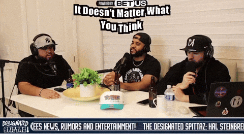 three men are sitting at a table with microphones and a sign that says it doesn 't matter what you think