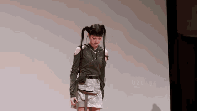 a woman with pigtails is standing in front of a projector screen that shows the time as 20:55