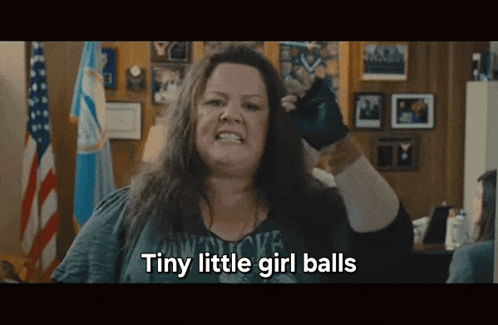 a woman says tiny little girl balls while holding a pair of boxing gloves