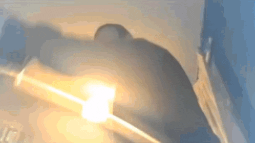 a blurry picture of a person standing in front of a light bulb .