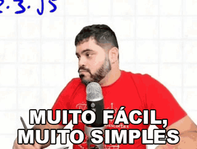 a man with a beard is talking into a microphone with the words " muito facil muito simples " on the bottom