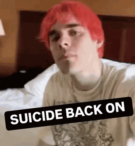 a young man with red hair is laying on a bed .