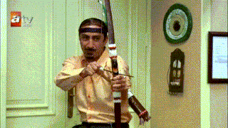 a man is holding a bow and arrow in front of a sign that says atv web