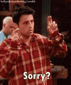 a man in a plaid shirt says sorry while making a peace sign