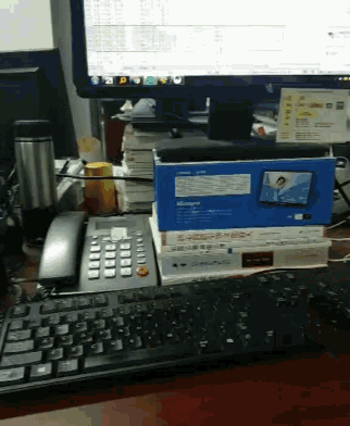 a stack of books sits on a desk next to a keyboard