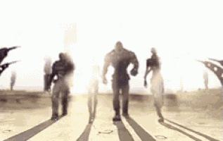 a group of people are walking down a street with their shadows cast on the ground .