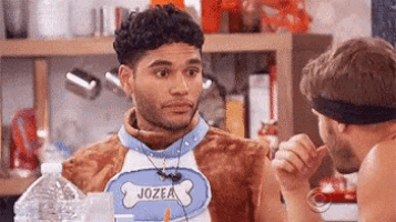 a man in a dog costume is talking to another man while holding a water bottle .