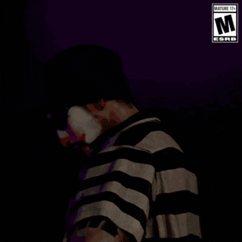 a man with a clown face painted on his face is wearing a striped shirt and a hat