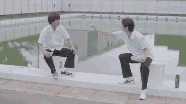 a young boy is being fed by another young boy
