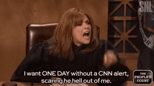 a woman in a judge 's robe is sitting at a table with her mouth open and yelling .
