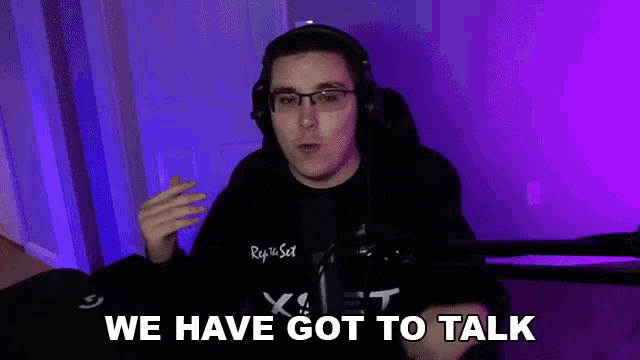 a man wearing headphones and glasses is talking into a microphone .