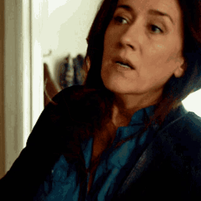 a close up of a woman 's face with a blue shirt