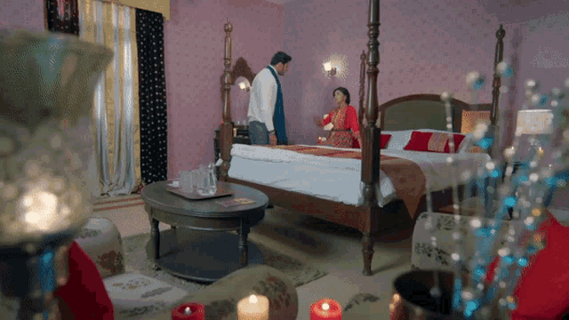 a man and a woman are standing in a bedroom