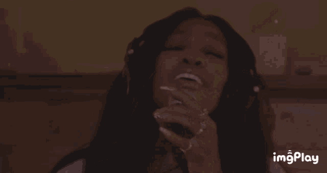 a woman is singing into a microphone with imgplay written on the bottom