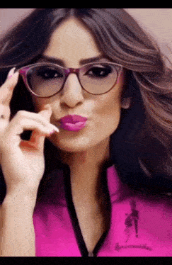a woman wearing glasses and purple lipstick is making a funny face