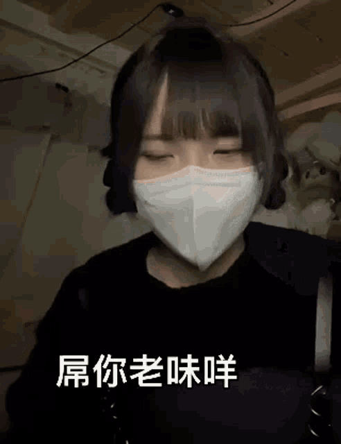 a girl wearing a mask with chinese writing on it is making a funny face .