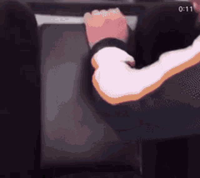 a person 's arm is shown in a blurry photo with the time of 1:11 in the corner