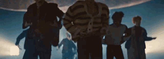 a group of men are dancing in a dark room .