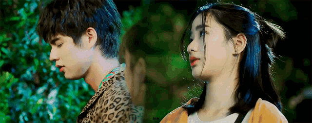 a man and a woman are looking at each other . the woman is wearing a leopard print shirt .