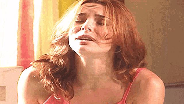 a woman in a pink tank top is crying