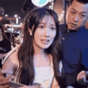 a woman is sitting in a crowd of people talking to a man .