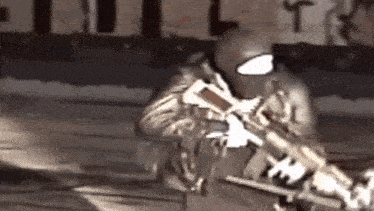 a man in a mask is holding a gun in his hand .