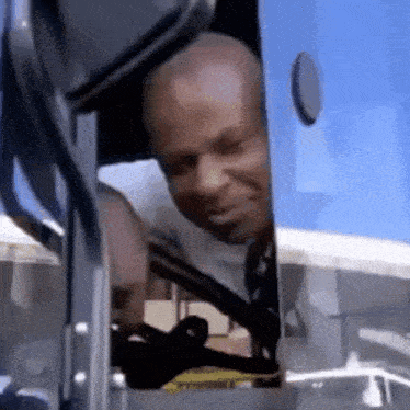 a man is sitting in the driver 's seat of a bus and looking out the window .
