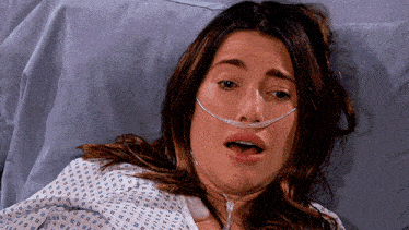 a woman laying in a hospital bed with an oxygen mask on her nose