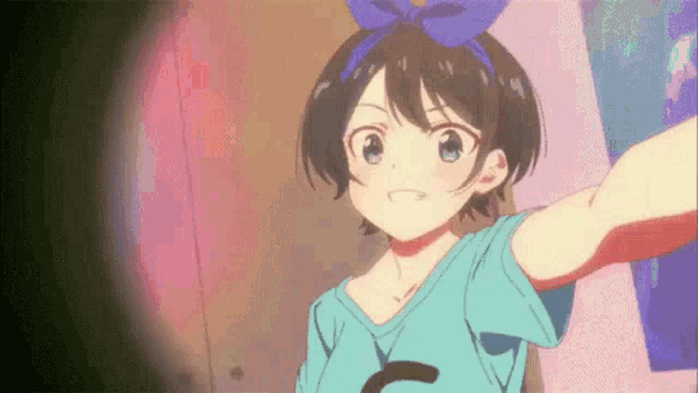 a girl in a blue shirt is taking a selfie with a bow in her hair .
