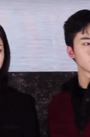 a man and a woman are standing next to each other and the man is wearing a red sweater