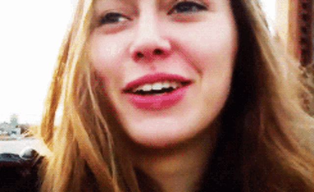a close up of a woman 's face shows her teeth