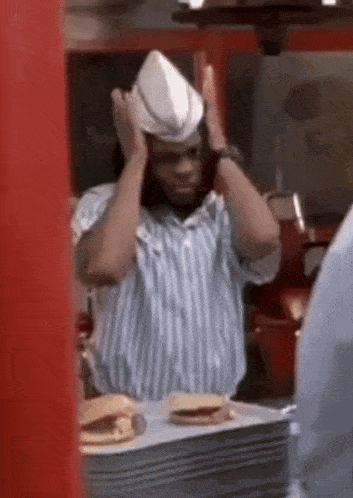 a man wearing a cowboy hat is covering his ears in a fast food restaurant .