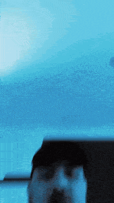 a blurry picture of a person 's face with a blue sky in the background