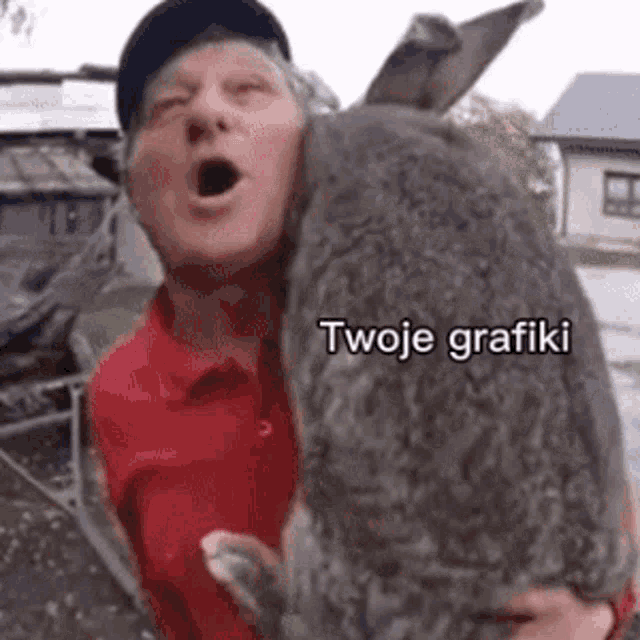 a man in a red shirt is holding a large rabbit with a caption that says twoje grafiki