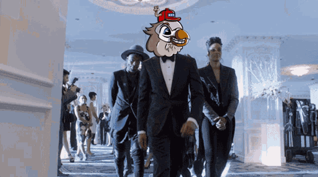 a man in a tuxedo has a cartoon bird on his head that says ' u.s.a. ' on it