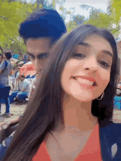 a man and a woman are posing for a picture and smiling for the camera .