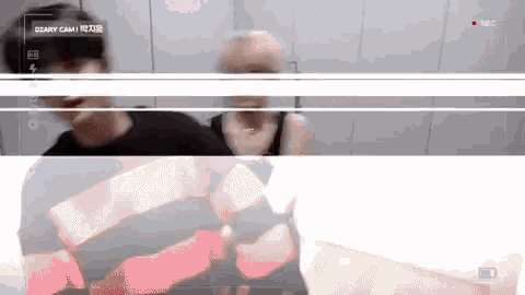 a man in a red and black striped shirt is being recorded on a camera