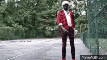 a man in a red and black plaid shirt is standing on a basketball court .