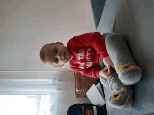 a little boy wearing a red shirt that says ' i 'm too tired ' on it