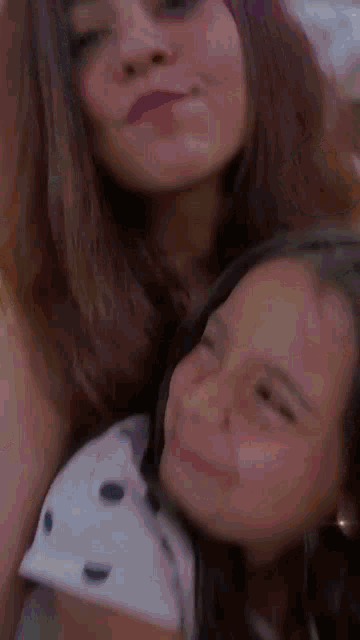 a woman and a little girl are posing for a picture together and smiling .