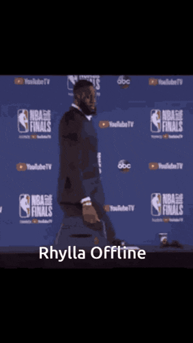 a man in a suit is standing in front of a wall that says ' nba finals ' on it