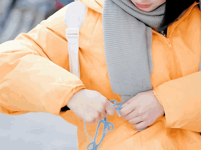 a woman wearing a yellow jacket and a scarf