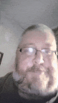 a man with a beard wearing glasses and a black shirt