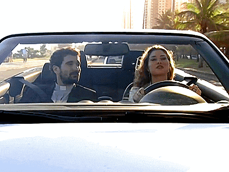 a man and a woman are driving a white car