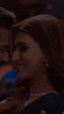 a woman in a blue saree is dancing in a crowd .