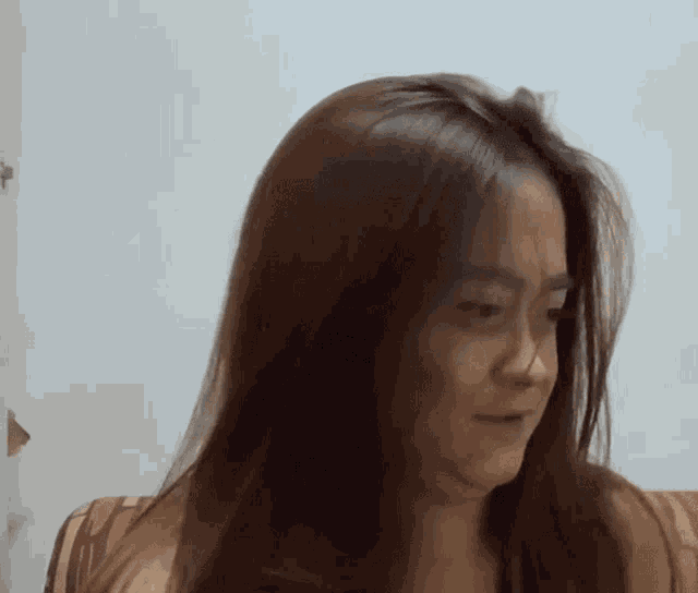 a woman with long hair is sitting on a couch